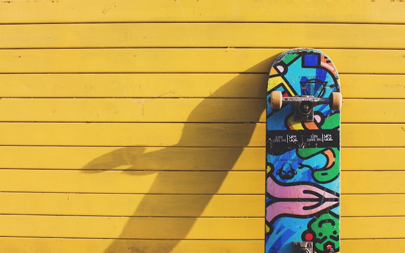 年轻人在城市街头玩滑板的动态瞬间，背景是涂鸦墙